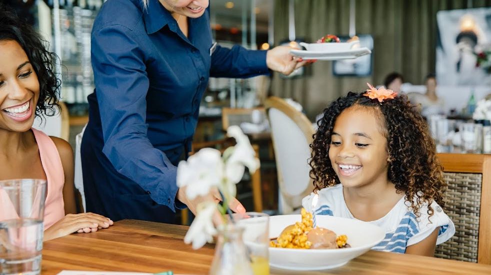 Woman and daughter being served at restaurant
